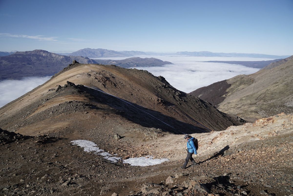 Caminante en el filo del Cerro Dedal sobre un mar de nubes
