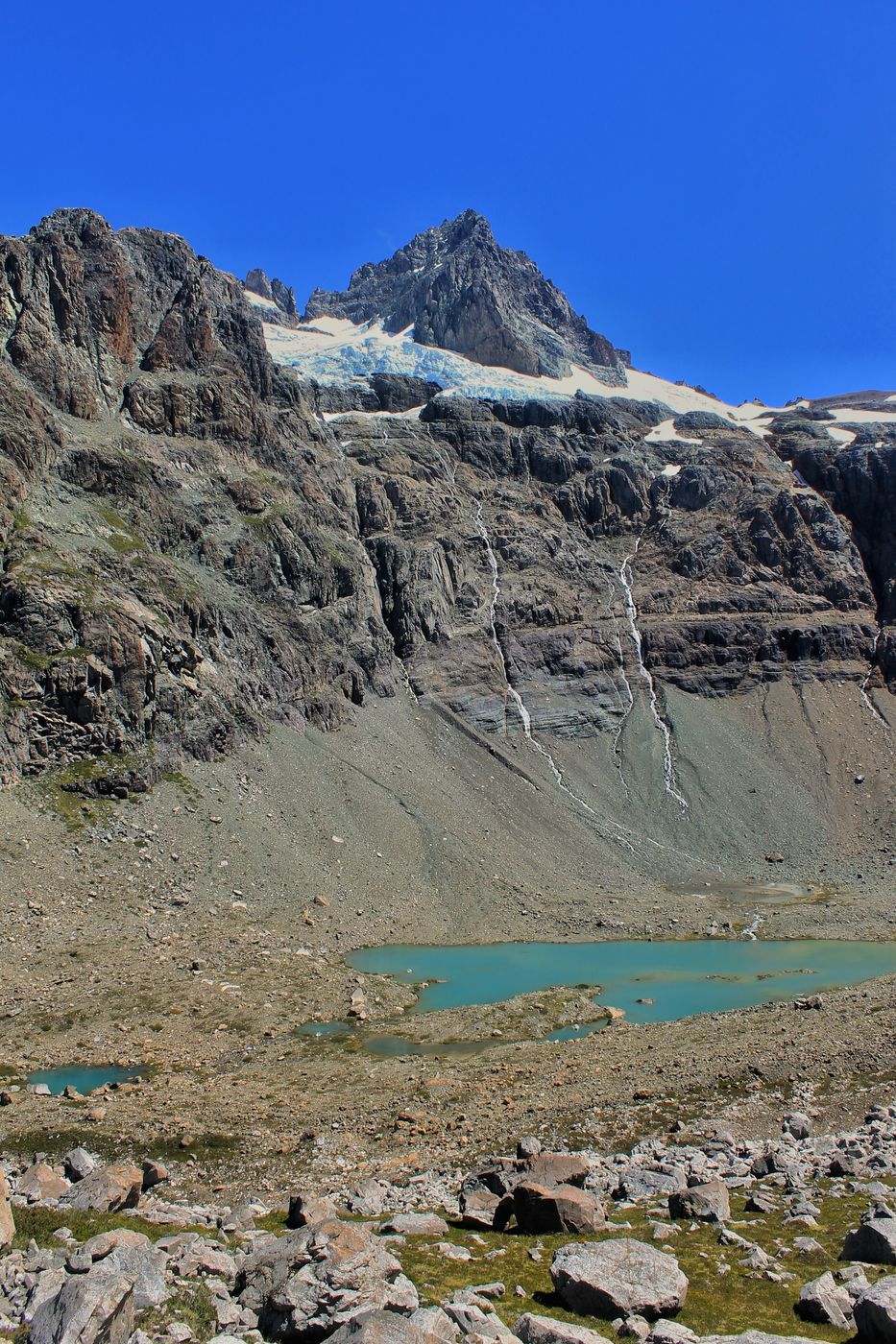 Laguna turquesa bajo las paredes del Cerro Cónico